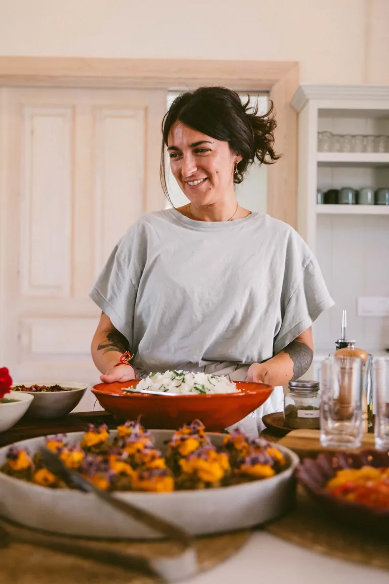 Natalia, chef and Ayurveda practitioner, standing in front of a buffet at Suniai Oliva.