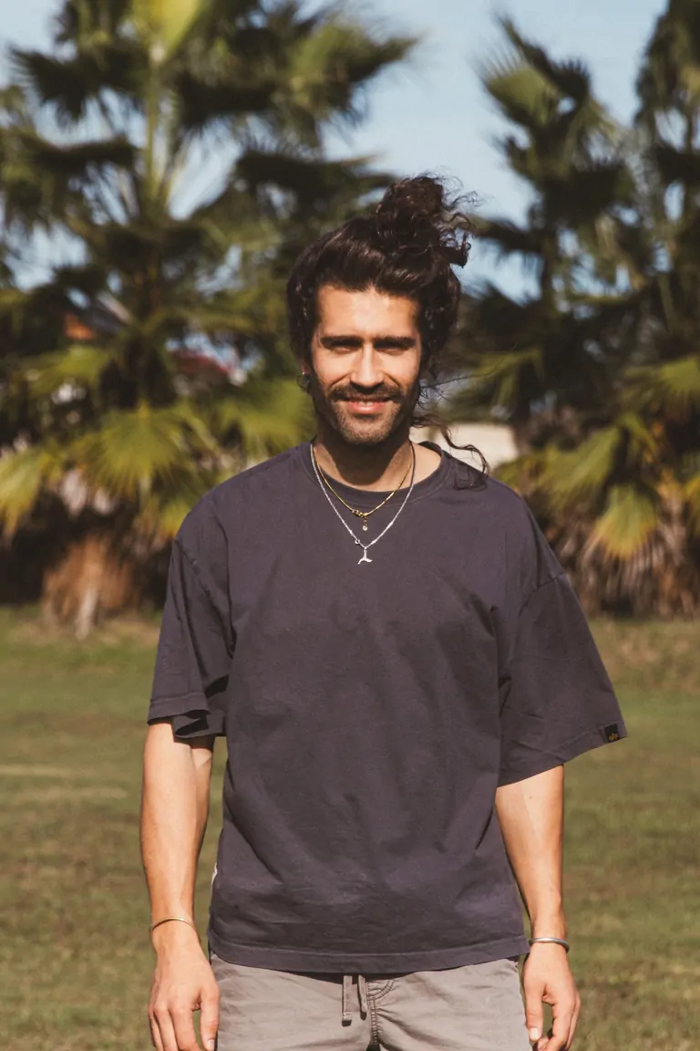 Marc, Marketing, Guest Relations & Photographer, smiles against a backdrop of palm trees.